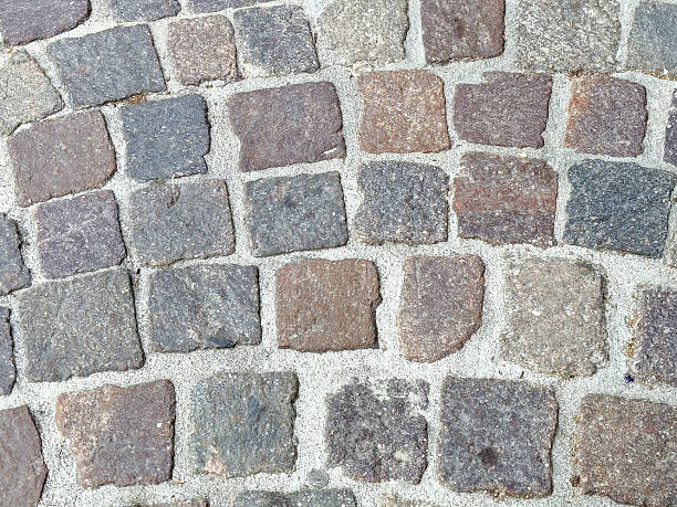 istock Close-up of cobblestone path texture with weathered stone blocks 2212857553