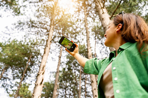 istock Active woman taking selfie with smartphone while walking in park or small forest. 2212861033