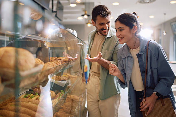 istock Happy couple talking while choosing what to buy in a bakery. 2212862172