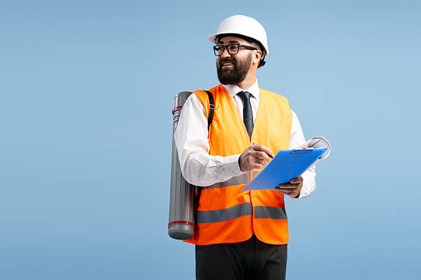 istock Smiling architect taking notes on a clipboard, carrying blueprints on his back 2212863342