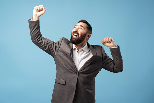 istock Enthusiastic businessman celebrating success with raised arms and cheerful expression 2212863534