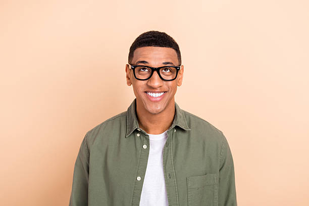 istock Portrait of nice cheerful guy beaming smile look interested up above empty space isolated on beige color background 2212867003