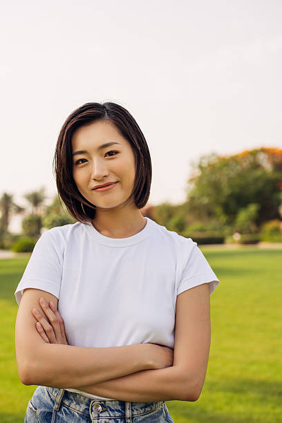 Confident Woman Smiling Outdoors in a Green Park Setting