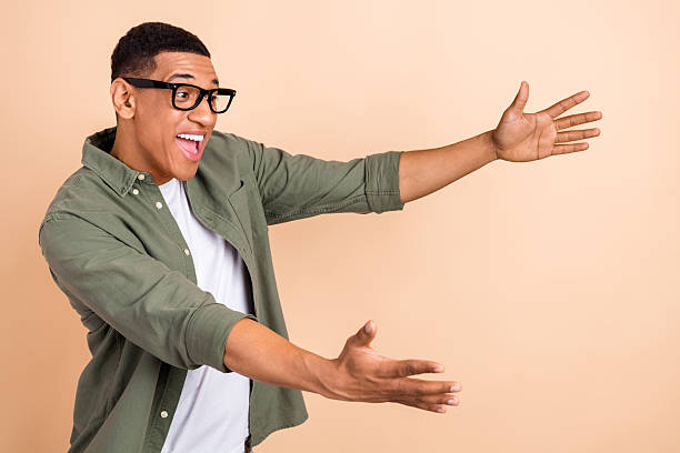 istock Photo of ecstatic overjoyed guy dressed khaki shirt glasses look empty space impressed catching gift isolated on pastel color background 2212869242