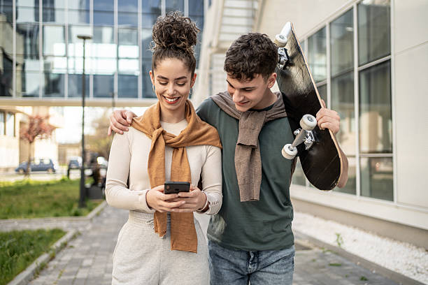 istock Teenagers walking and using a smartphone in an urban setting 2212877936