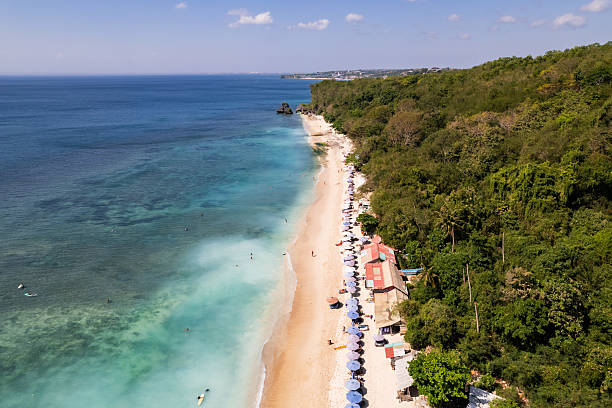 istock Tourists relaxing on sandy beach in bali, indonesia 2212879980