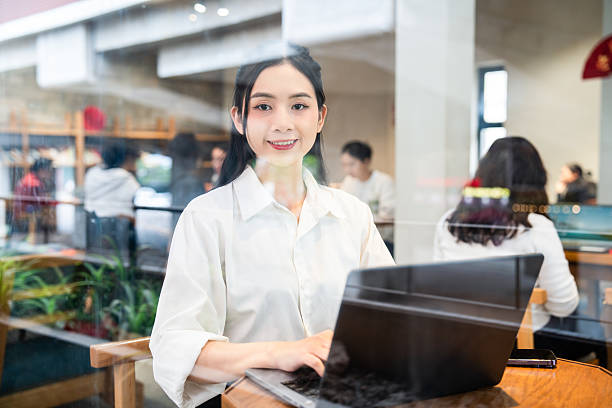 istock Young woman works on laptop in bright cafe with visible reflection creating vibrant atmosphere 2212881903