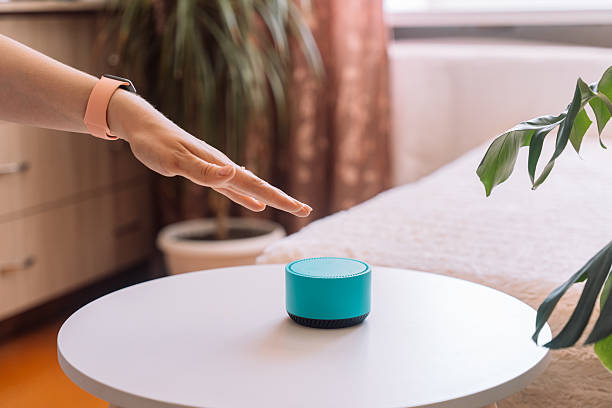 istock A woman's hand touches a blue smart speaker on the table 2212892451