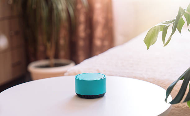istock Blue wireless smart speaker on white table in room 2212892460