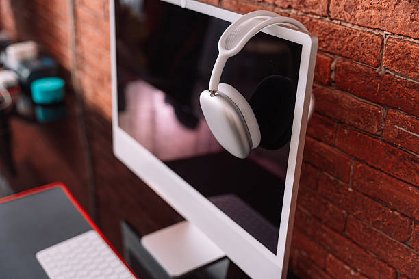 Wireless headphones hanging on a monoblock on a black table.