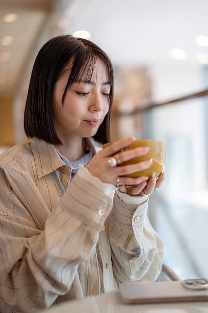 Female freelance worker drinking a cup of tea in cafe