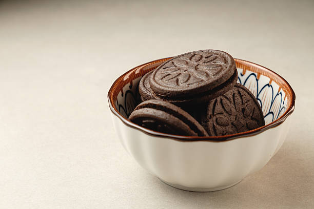 istock Delicious chocolate cookies in a decorative bowl on a light surface 2212900260