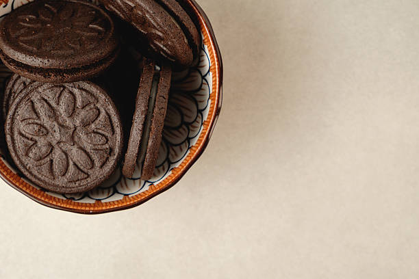 Delicious chocolate cookies in a decorative bowl on a light background