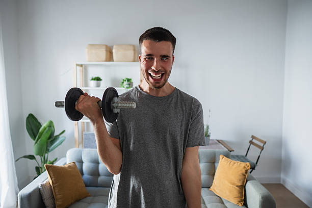istock Blind man lifting weights and smiling at home 2212901101