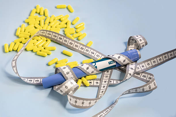 istock Ozempic syringe pen and measuring tape on blue background. 2212904512