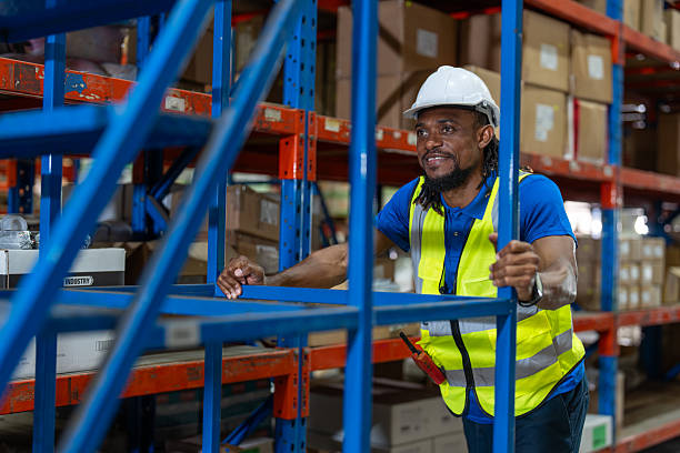 istock African American man warehouse worker moving stairs between checking inventory on shelf. Logistics, Distribution Center concept. 2212907207