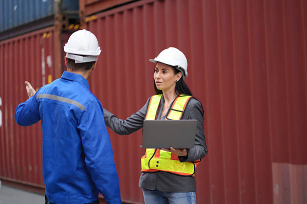 istock Caucasian man and woman engineer worker working and talking together at container site 2212909079