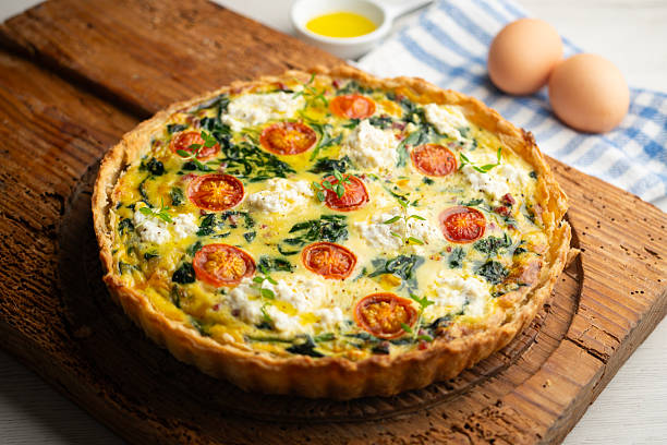 istock French quiche with spinach, cheese, tomatoes, and diced ham. Traditional recipe. 2212909346