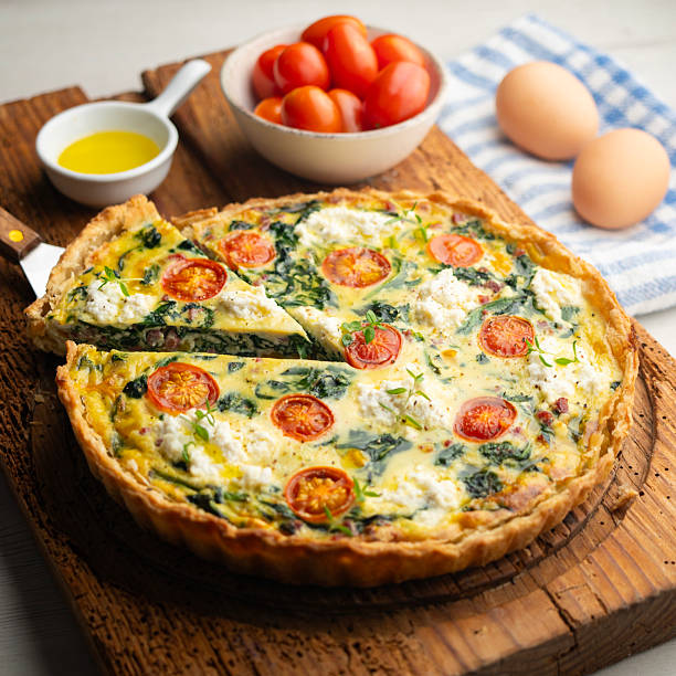 istock French quiche with spinach, cheese, tomatoes, and diced ham. Traditional recipe. 2212909387