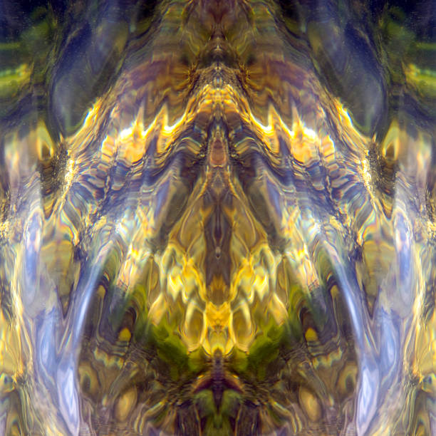 Whimsical glare and reflections, algae and stones under transparent water. symmetrical vertically
