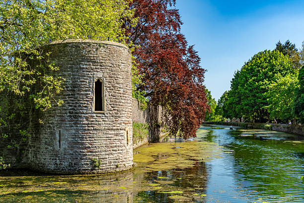Wells, UK. 29 April 2025. Wells Cathedral Bishops Palace exterior wall and waterway