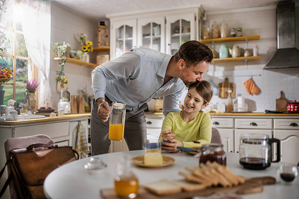 istock A father and his daughter having their breakfast at home ,while dad uses laptop 2212911577