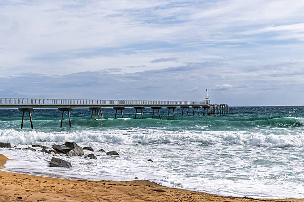 istock Pier Extending Over Turbulent Ocean Waves 2212916915