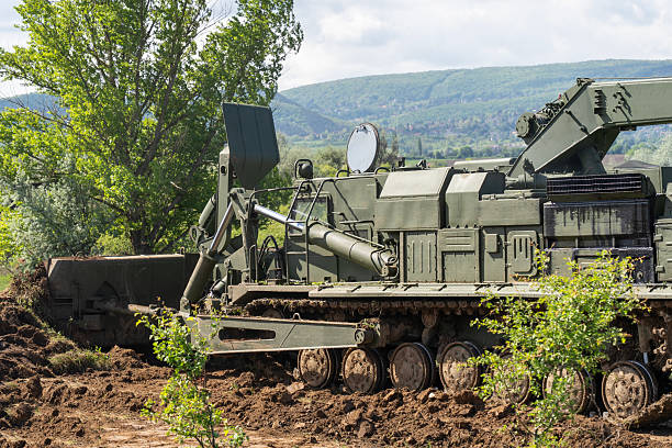 Green military engineering vehicle with crane and bulldozer blade