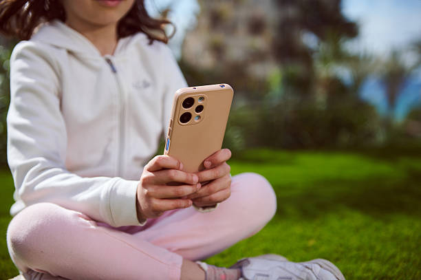 istock Young Girl Using Smartphone Outdoors in a Green Park Setting 2212919224