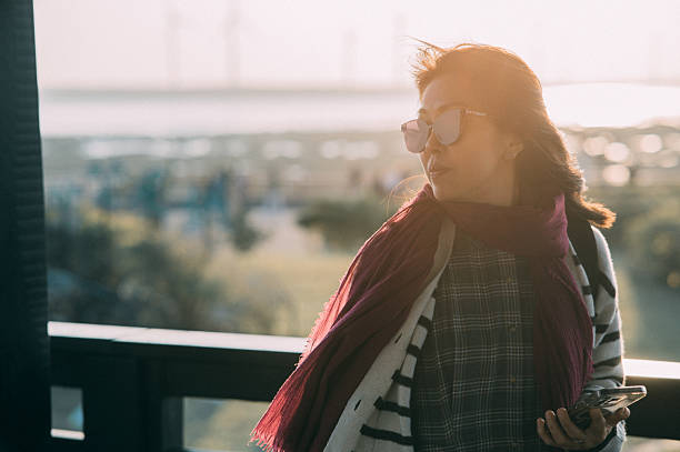 Portrait of an Asian woman traveler enjoying quiet time in the wetlands at sunset.