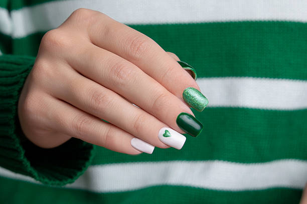 istock Female hands with green manicure nails 2212926294
