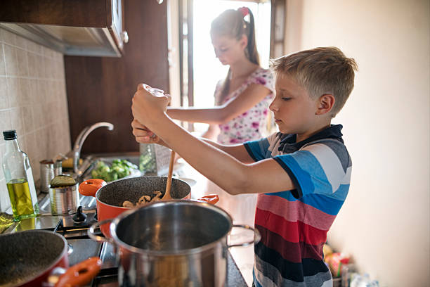 istock Children having fun cooking meal together in a cozy kitchen 2212929939