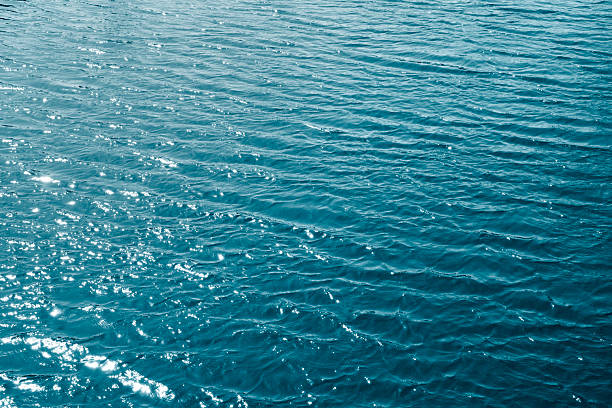 istock water texture with light reflections and small waves. Ocean water texture or background. 2212937687
