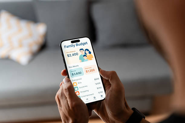 istock Man managing family budget using mobile phone app at home 2212937780