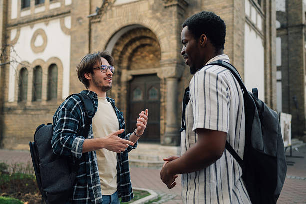 istock Two young students talking in front of university building 2212940207