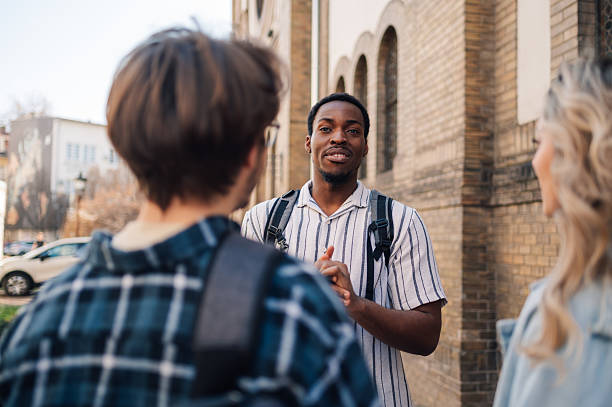Young man explaining something to his friends outdoors