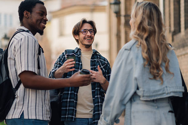 istock Cheerful university students chatting and drinking coffee outdoors 2212940242