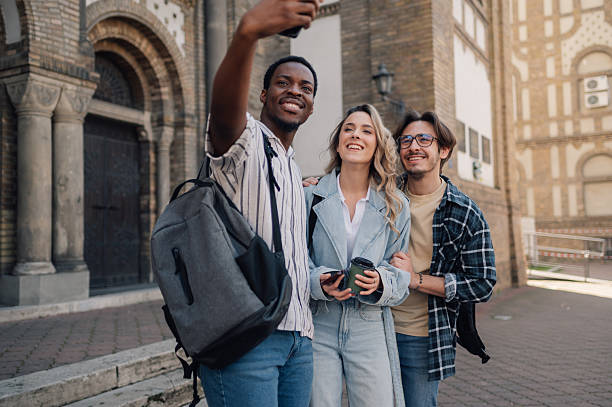 istock Three young adults taking a selfie in front of a building 2212940259
