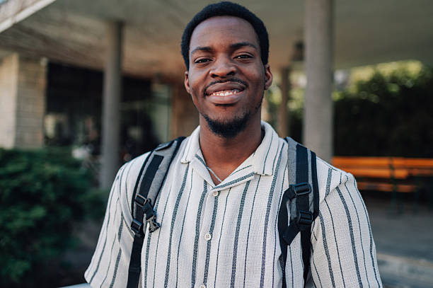 istock Portrait of a smiling young man wearing backpack in urban setting 2212940320