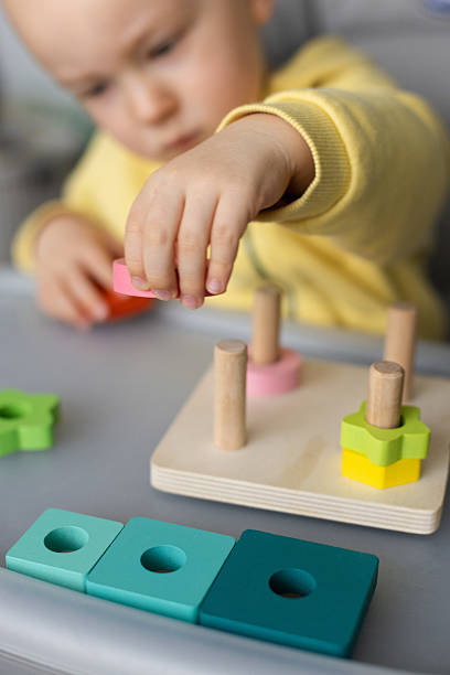 istock Baby playing with educational toy, Cognitive skills, Montessori activity. Closeup, selective focus. 2212940843