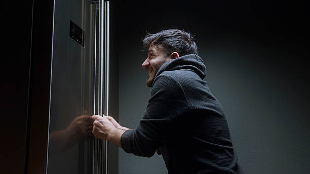 istock Young man caught sneaking snacks from kitchen at night looking startled in dark hallway 2212943232