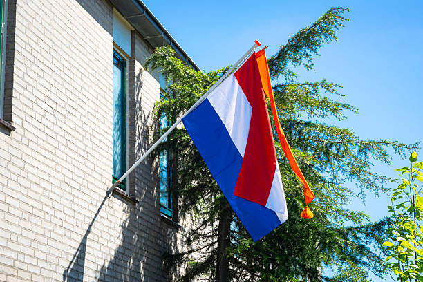 National dutch flag flying in the wind against a clear sky, symbolizing nation and identity