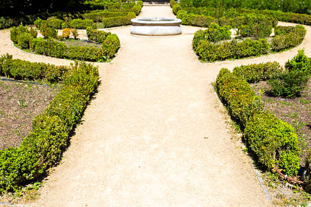 istock Fountain on a walk bounded by bushes 2212949115
