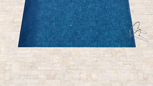 istock Swimming Pool With Blue Tiles and Stone Paver Deck in Sunlight 2212952285
