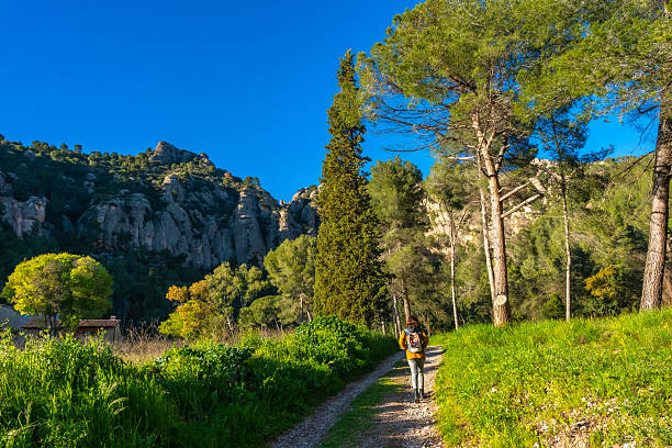 Female tourist walking alone on a path in montserrat mountain, near barcelona, catalonia, spain