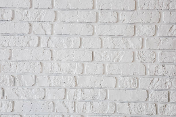 istock Textured white brick wall with a rustic appearance and even spacing of bricks for design 2212952854