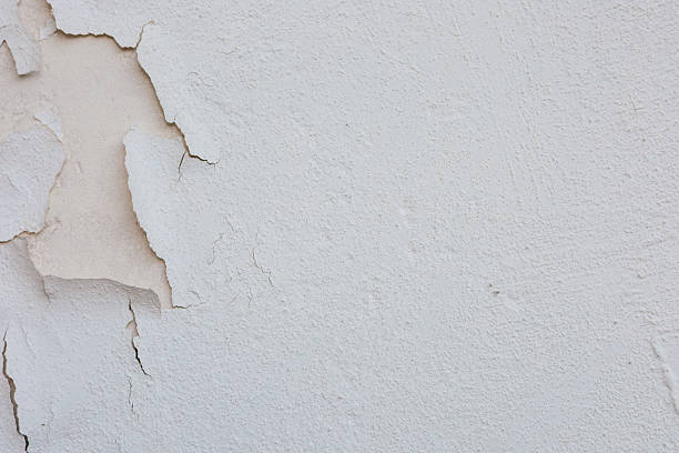 istock Cracked plaster wall with peeling paint reveals underlying texture in indoor setting 2212953730