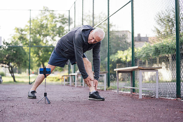 istock Elderly man bending down to stretch outdoors 2212954435