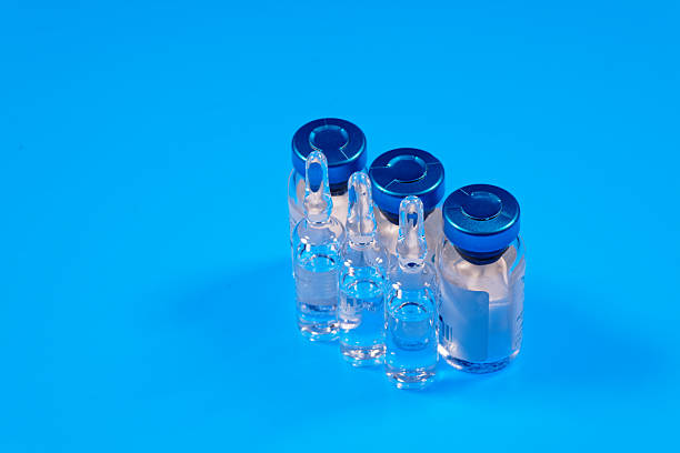 istock Medical glass ampoules on blue background. Selective focus 2212955800
