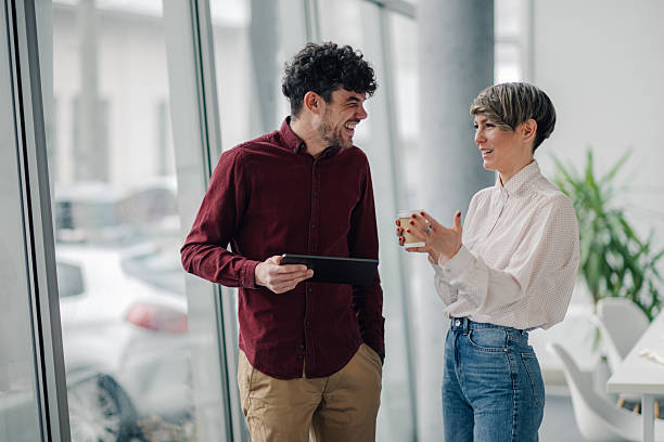 istock Young business people talking and laughing during a coffee break at the office 2212957156